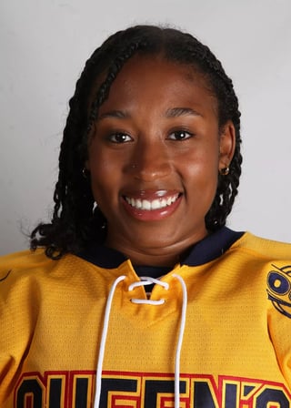 Portrait of a smiling woman wearing a yellow and navy sports jersey with braided hair against a white background