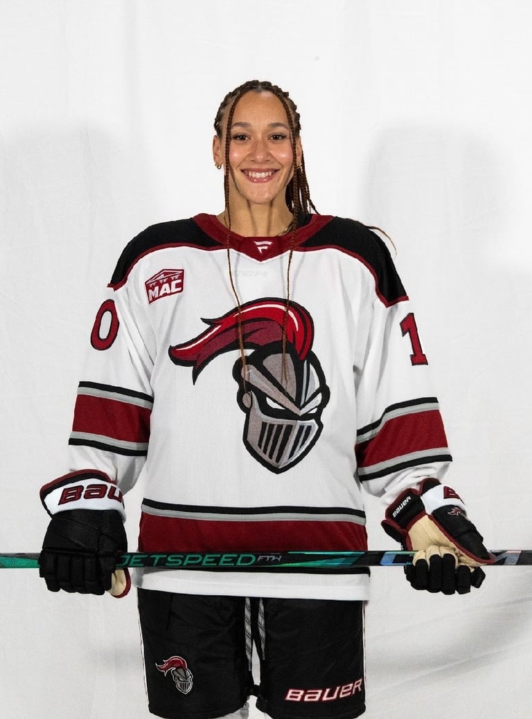 Smiling woman with braided hair wearing a gold and navy sports jersey with red lettering